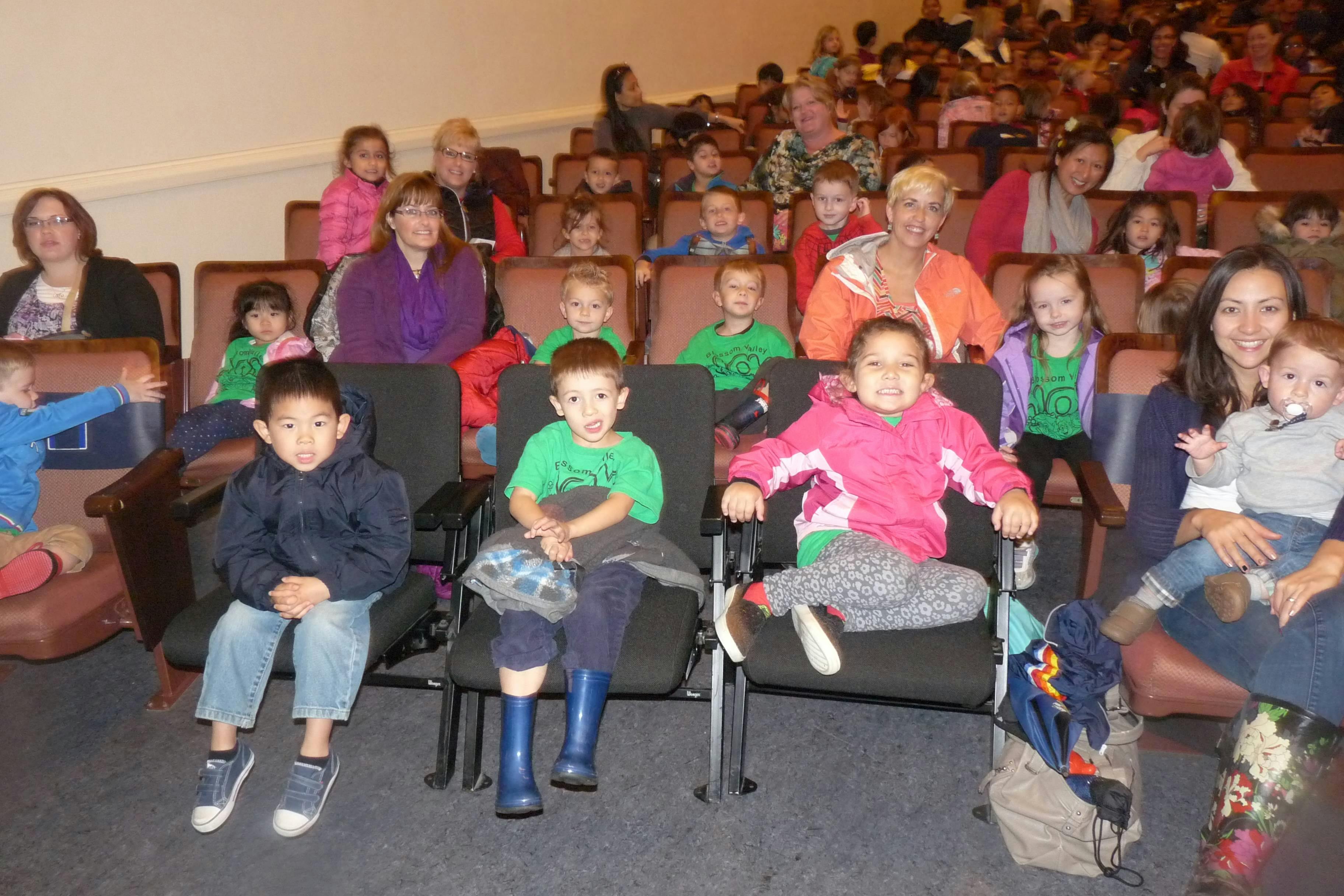 Adults and children sitting in an auditorium