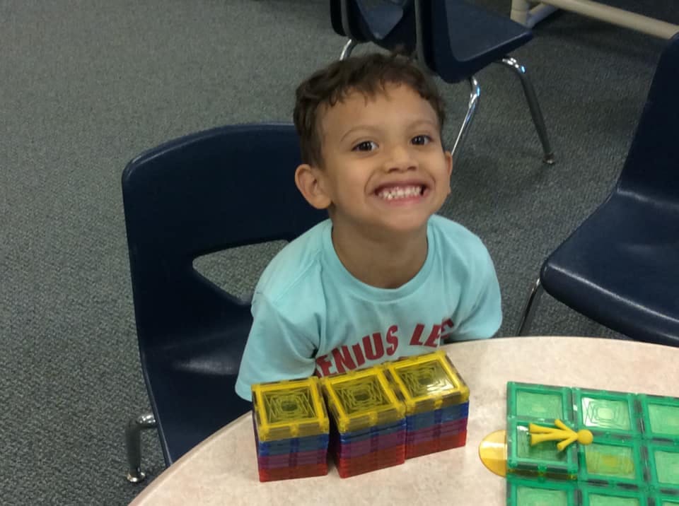 Child sitting at a table with colorful blocks
