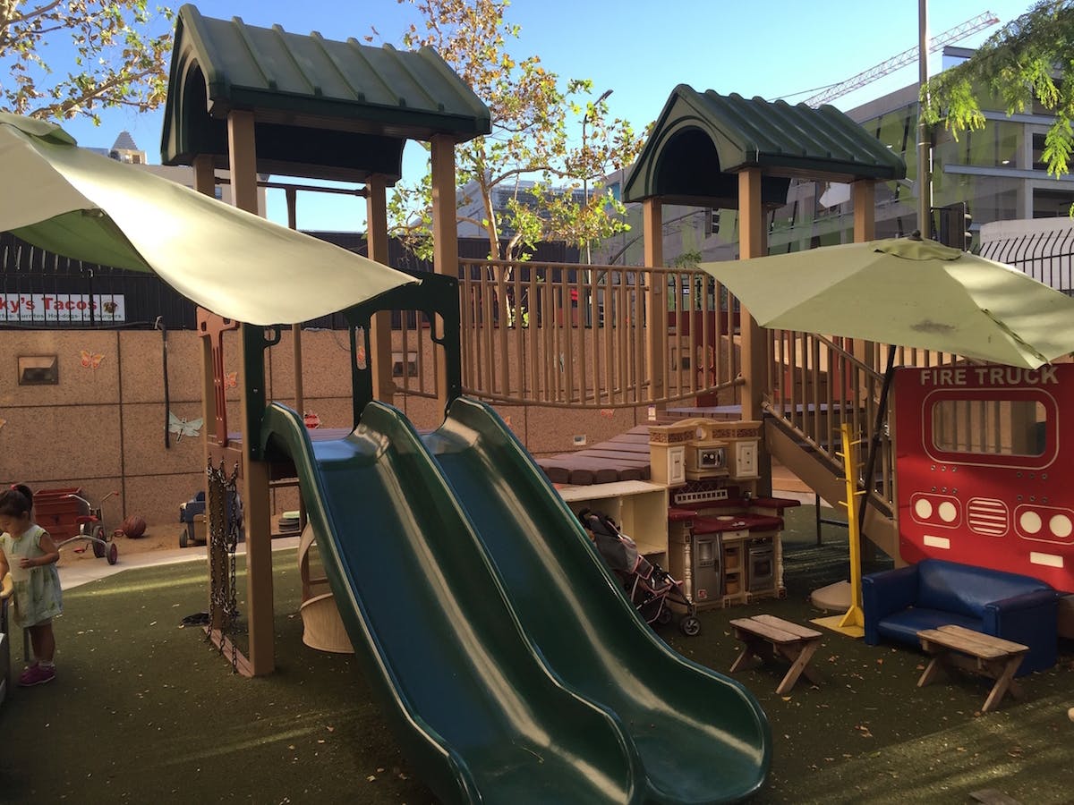 Playground with slides, climbing structure, and red play fire truck