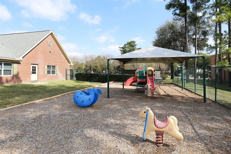 Outdoor playground with spring riders and a covered play structure