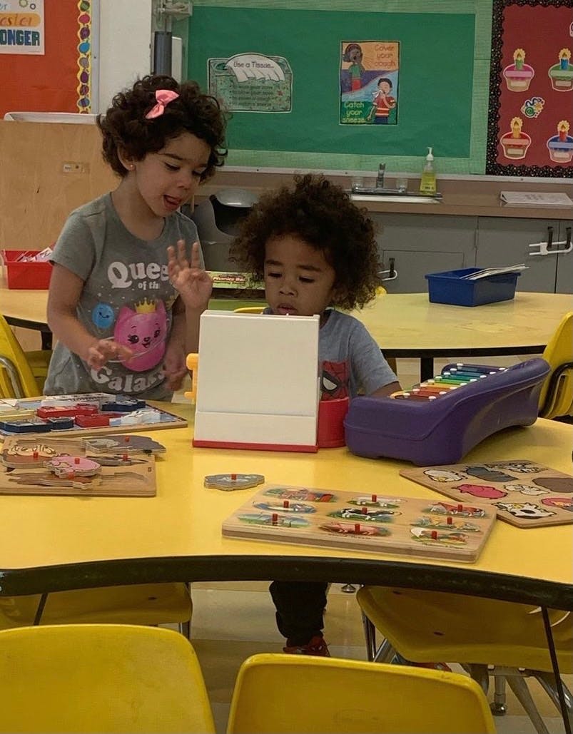 Two children playing with toys at a table