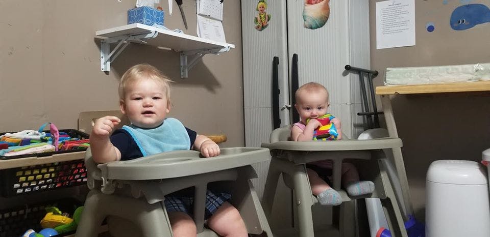 Two babies sitting in high chairs