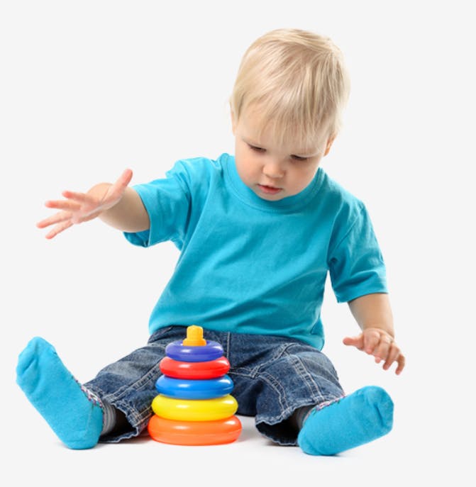 Child sitting and playing with a stacking ring toy