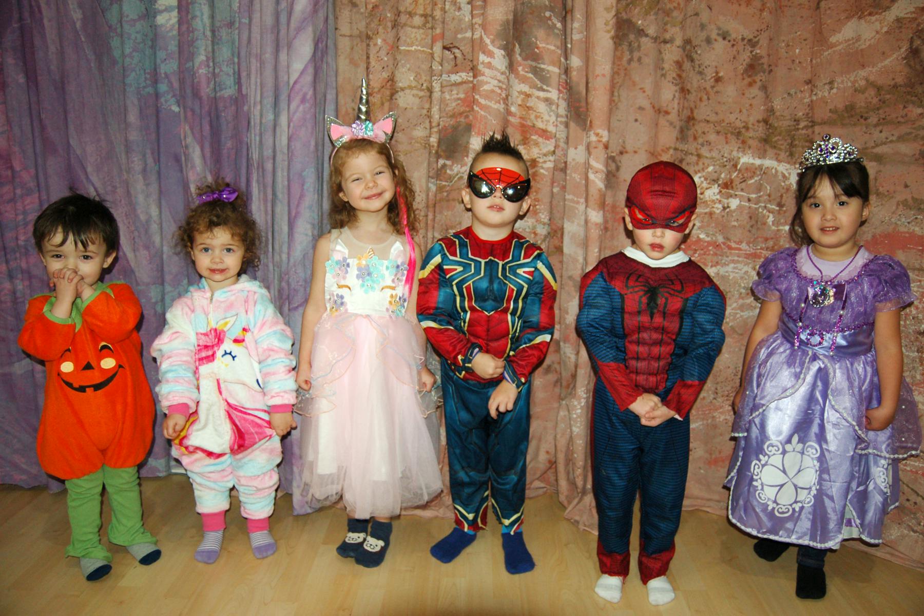 Six children in costumes standing in a row