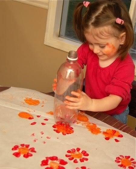 Child making flower prints with a plastic bottle