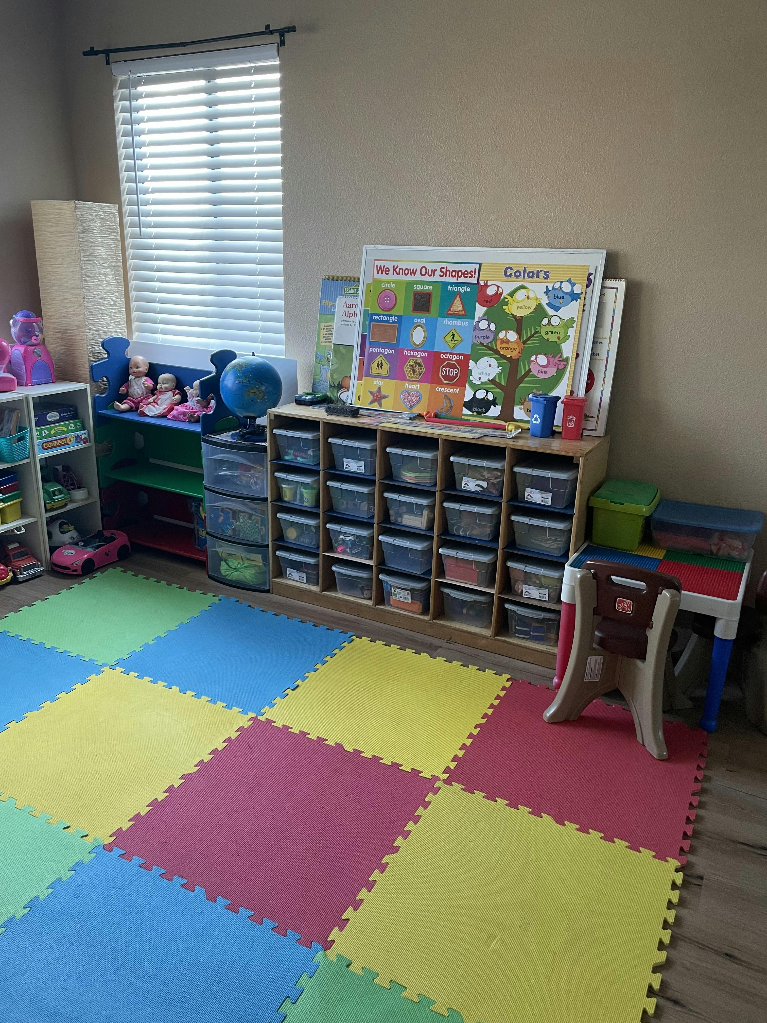 Playroom with storage units, toys, and a colorful foam floor mat