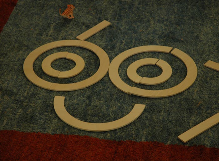 Wooden rings and curved pieces arranged to form a smiling face