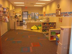 Empty classroom with colorful carpet and shelves
