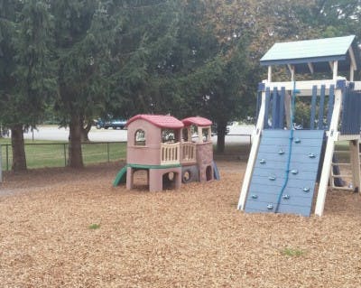 Playground with a small playhouse and a climbing wall