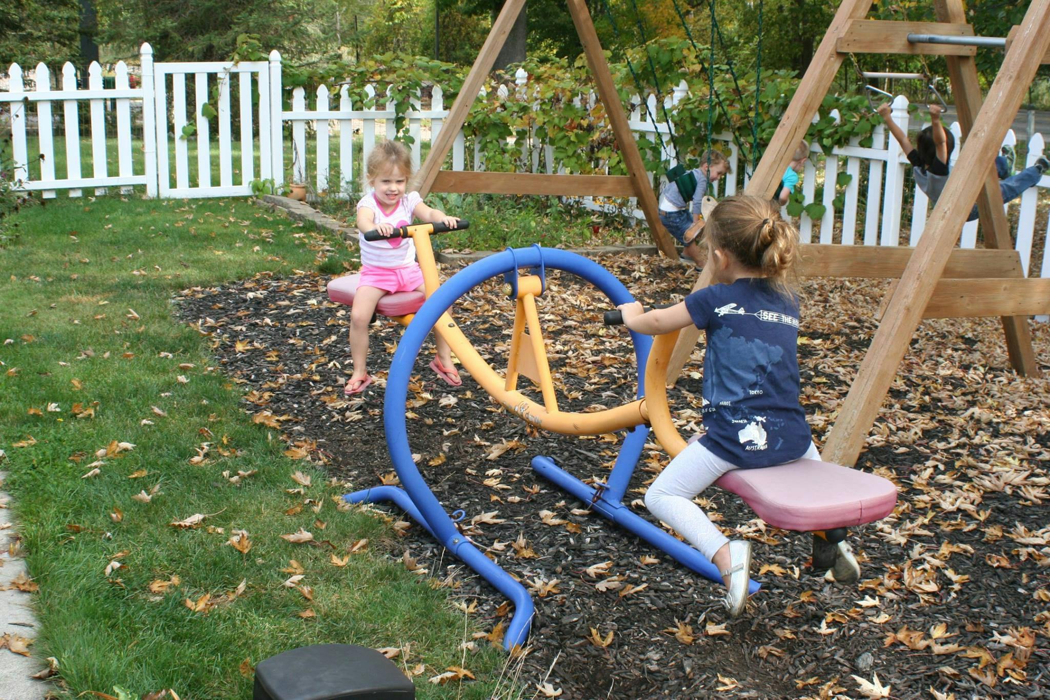 Two children playing on a seesaw in a playground
