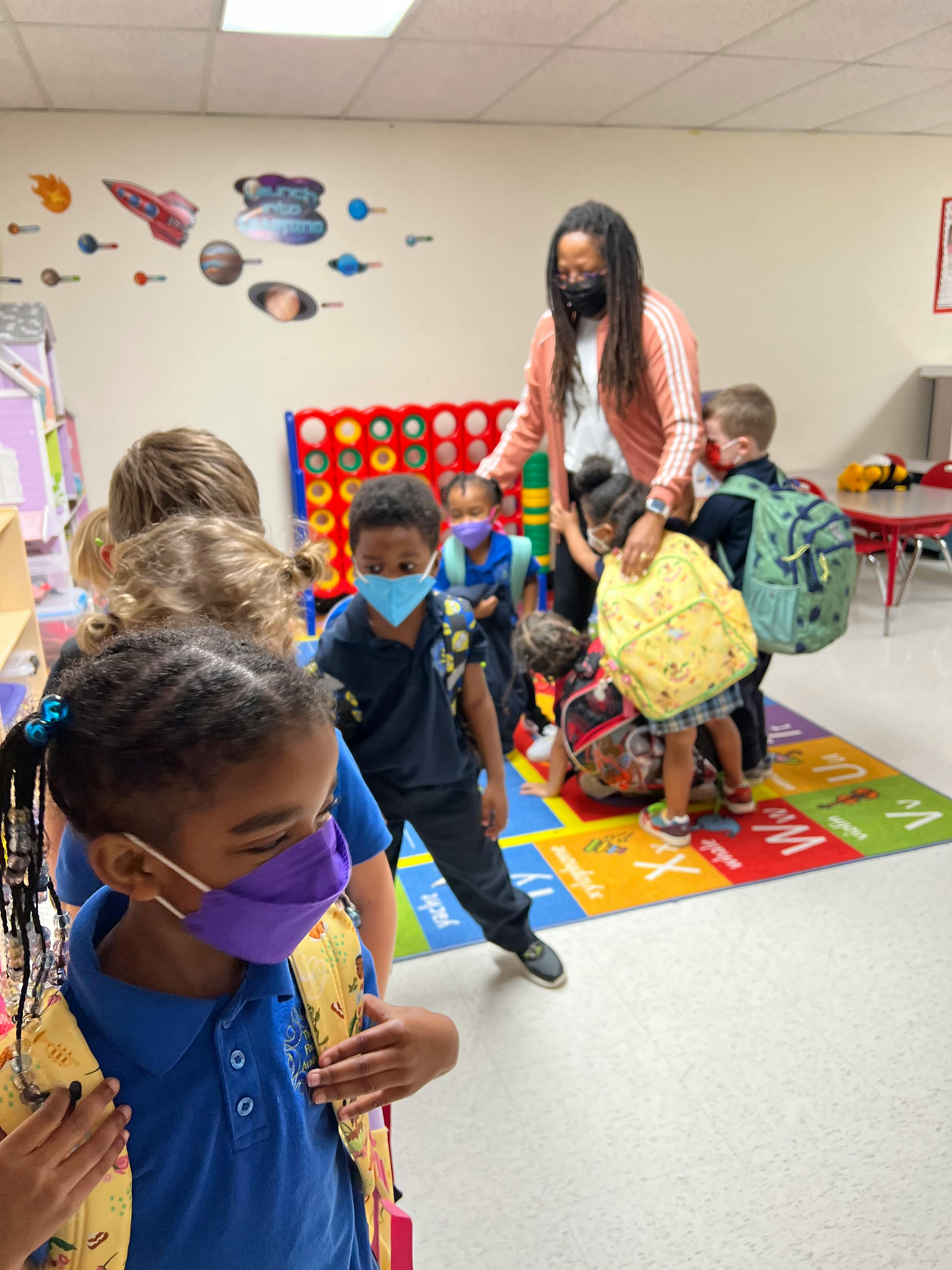 Adult and children wearing masks in a classroom