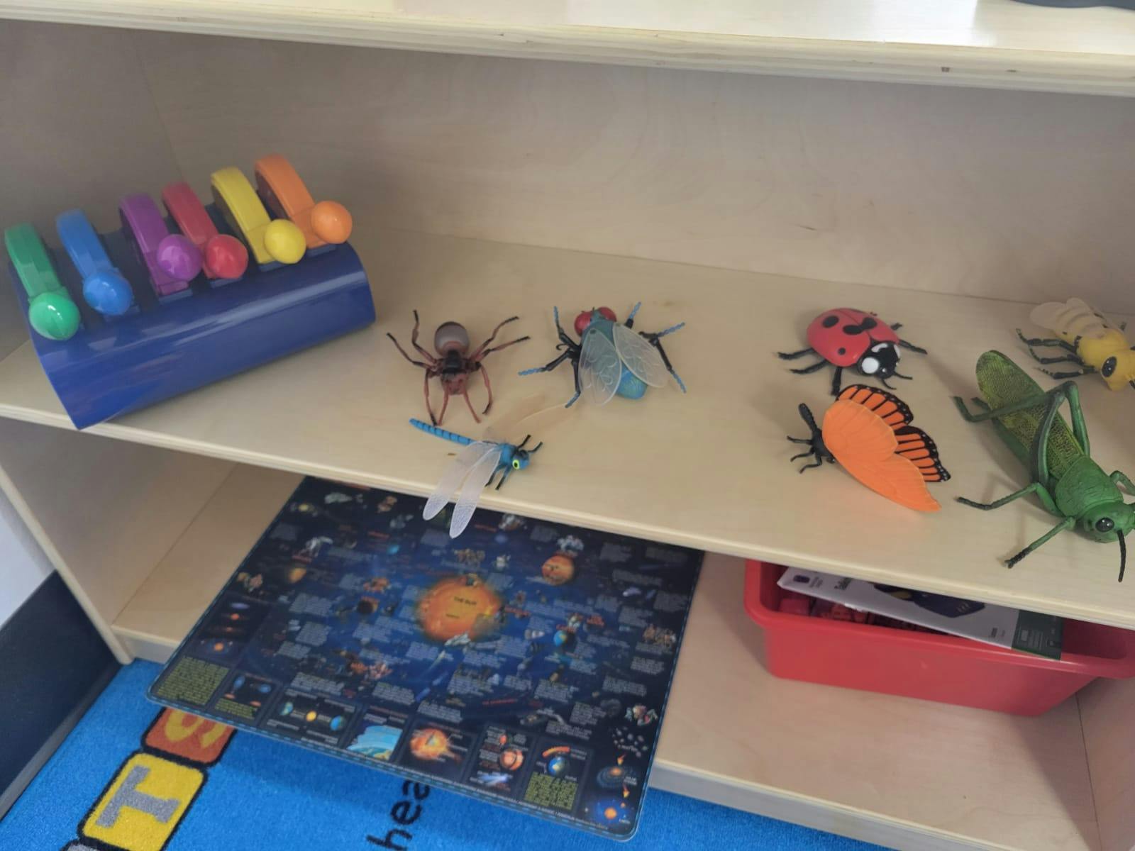Toy insects and a xylophone on a shelf
