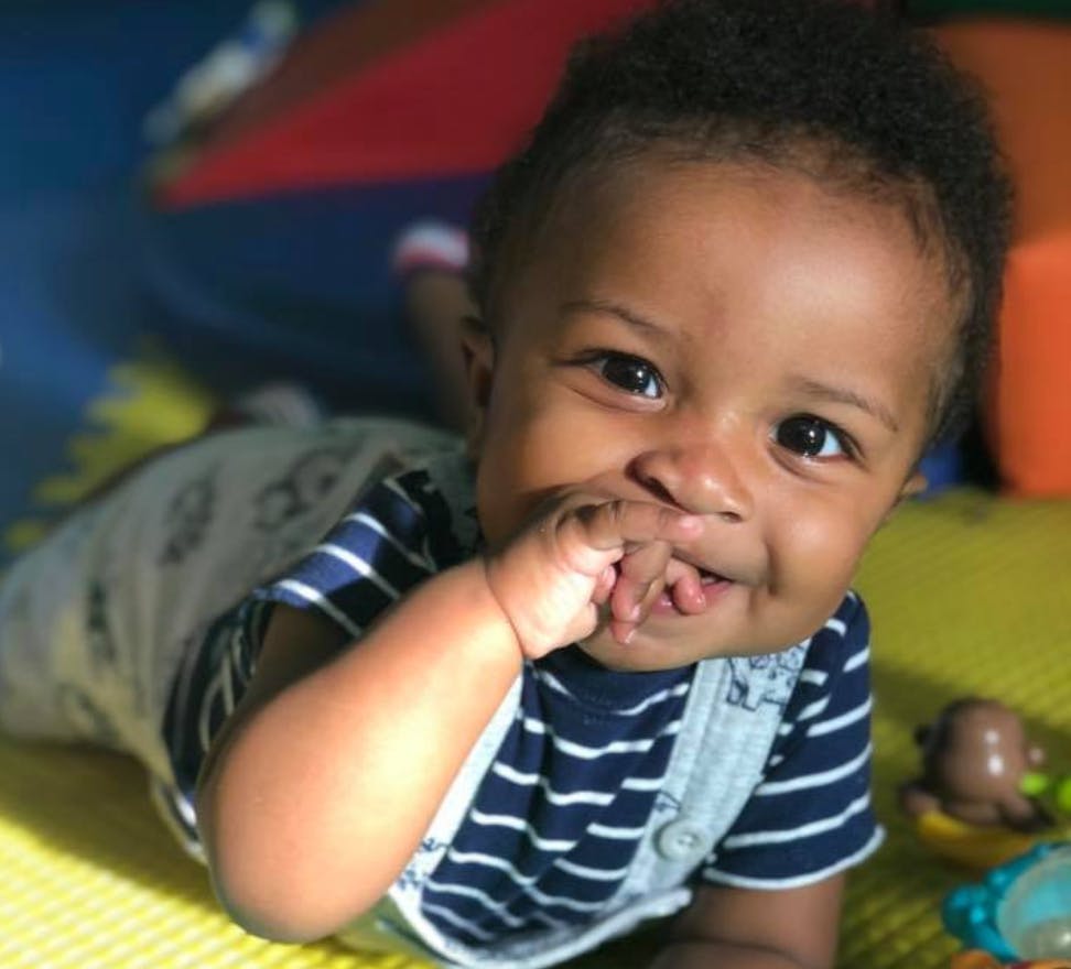 Child on stomach with hand near mouth