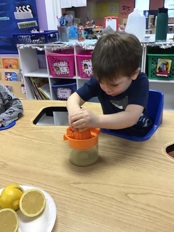 Child squeezing a lemon with a juicer