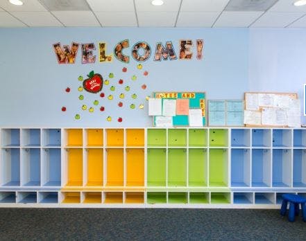 Classroom wall with "WELCOME" sign and colorful cubbies