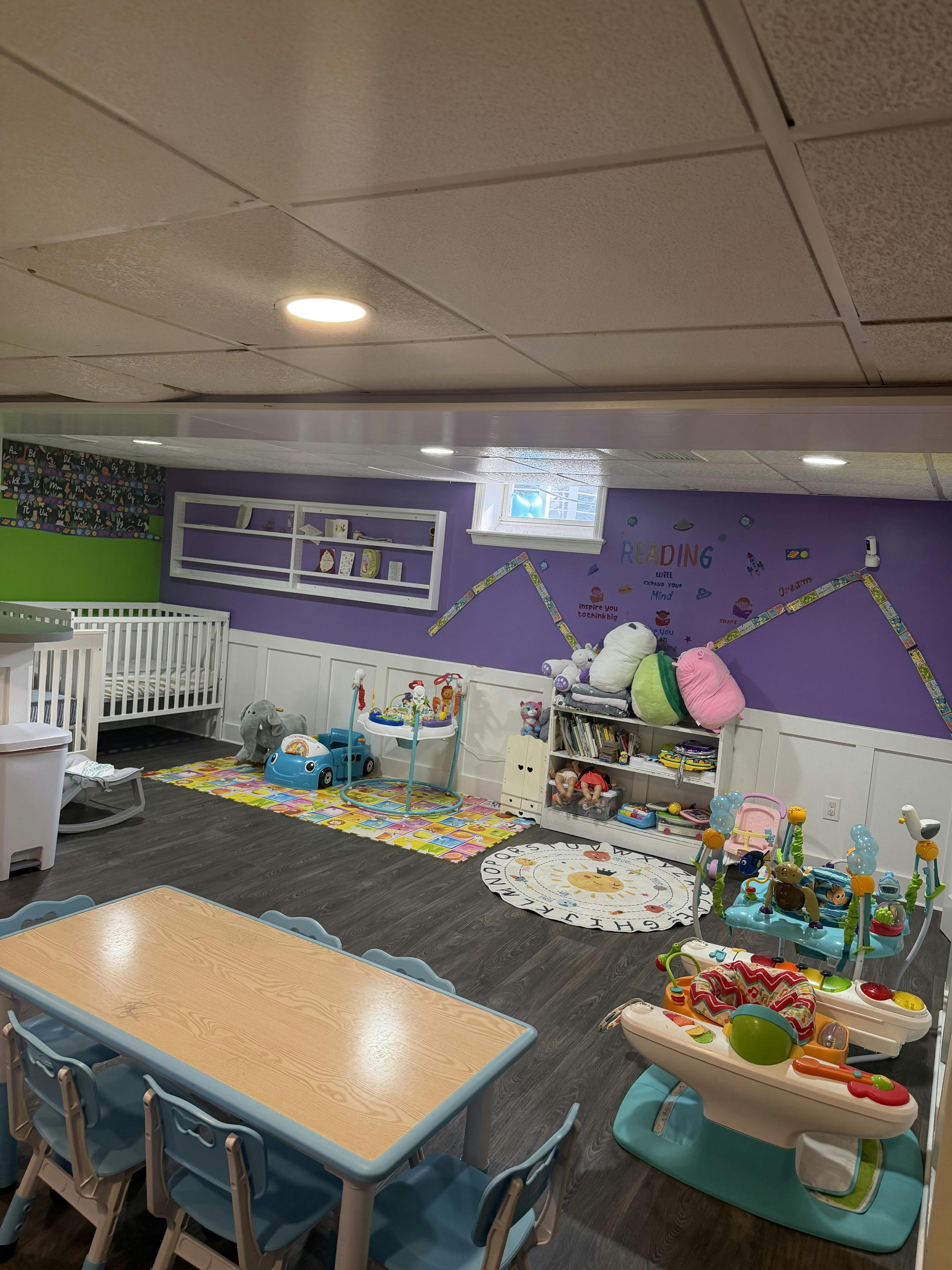 Playroom with a crib table chairs and various infant toys