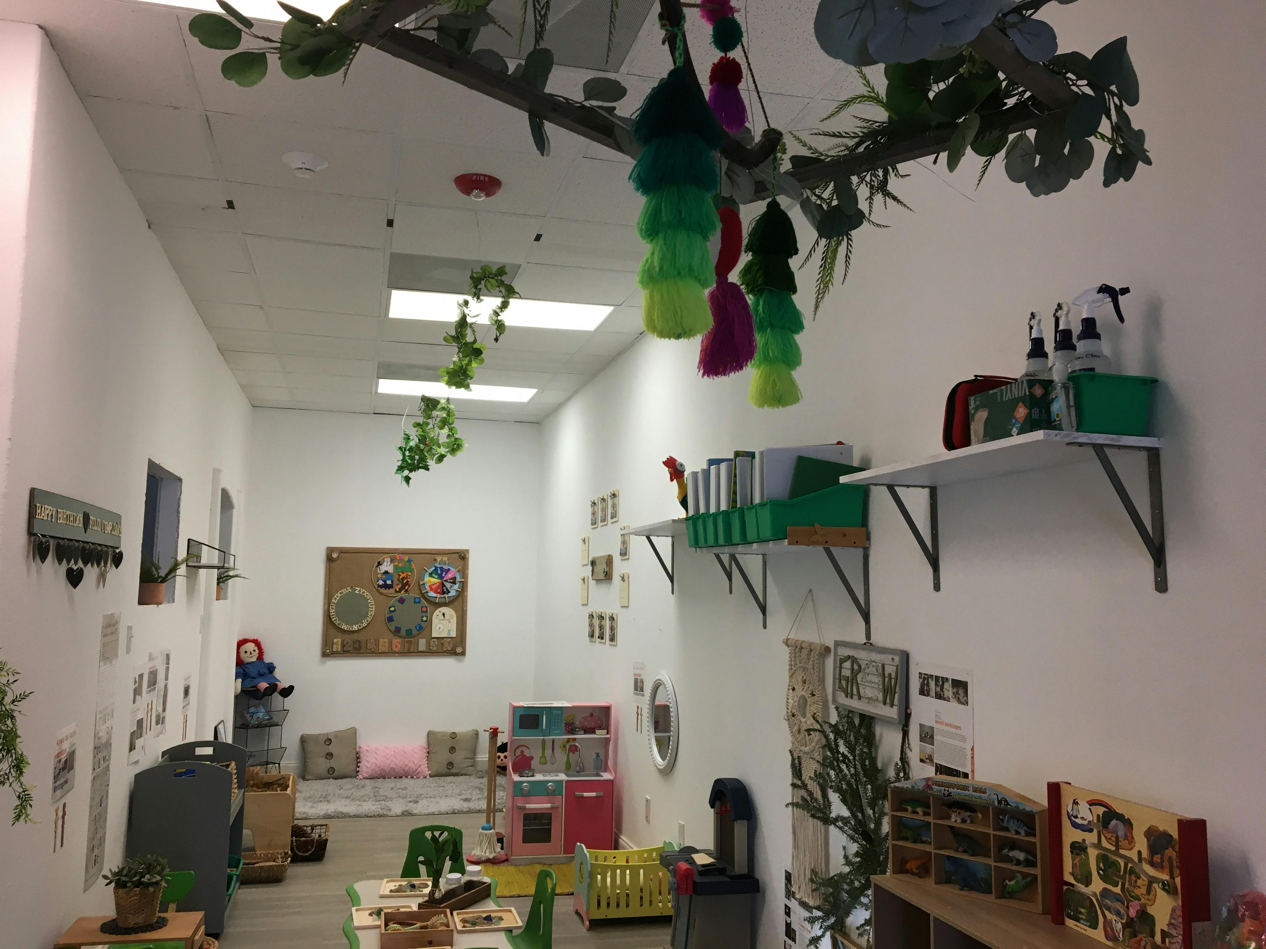 Classroom with shelves, bulletin board, and hanging decorations