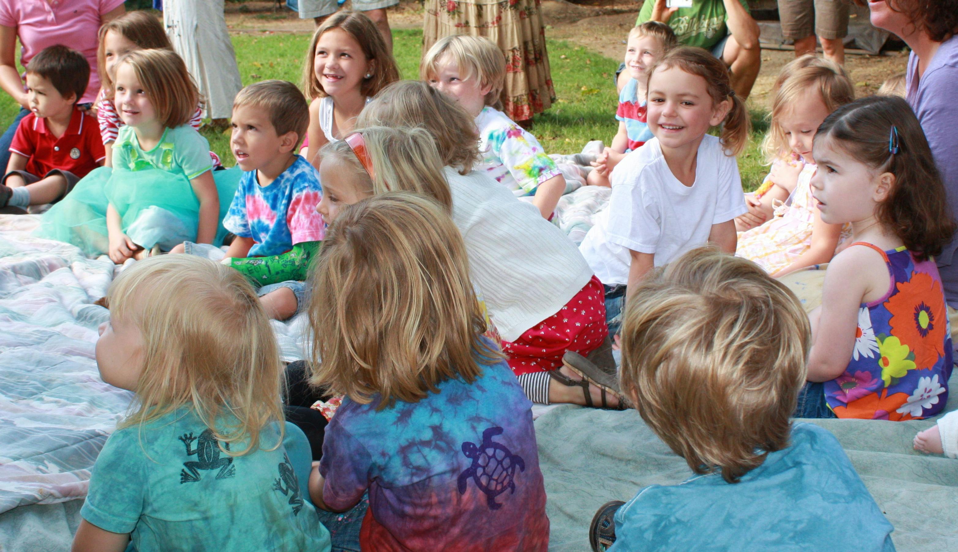 Group of children sitting on a blanket outdoors