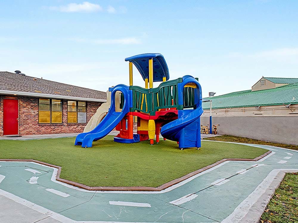 Colorful playground structure on artificial turf with a painted track