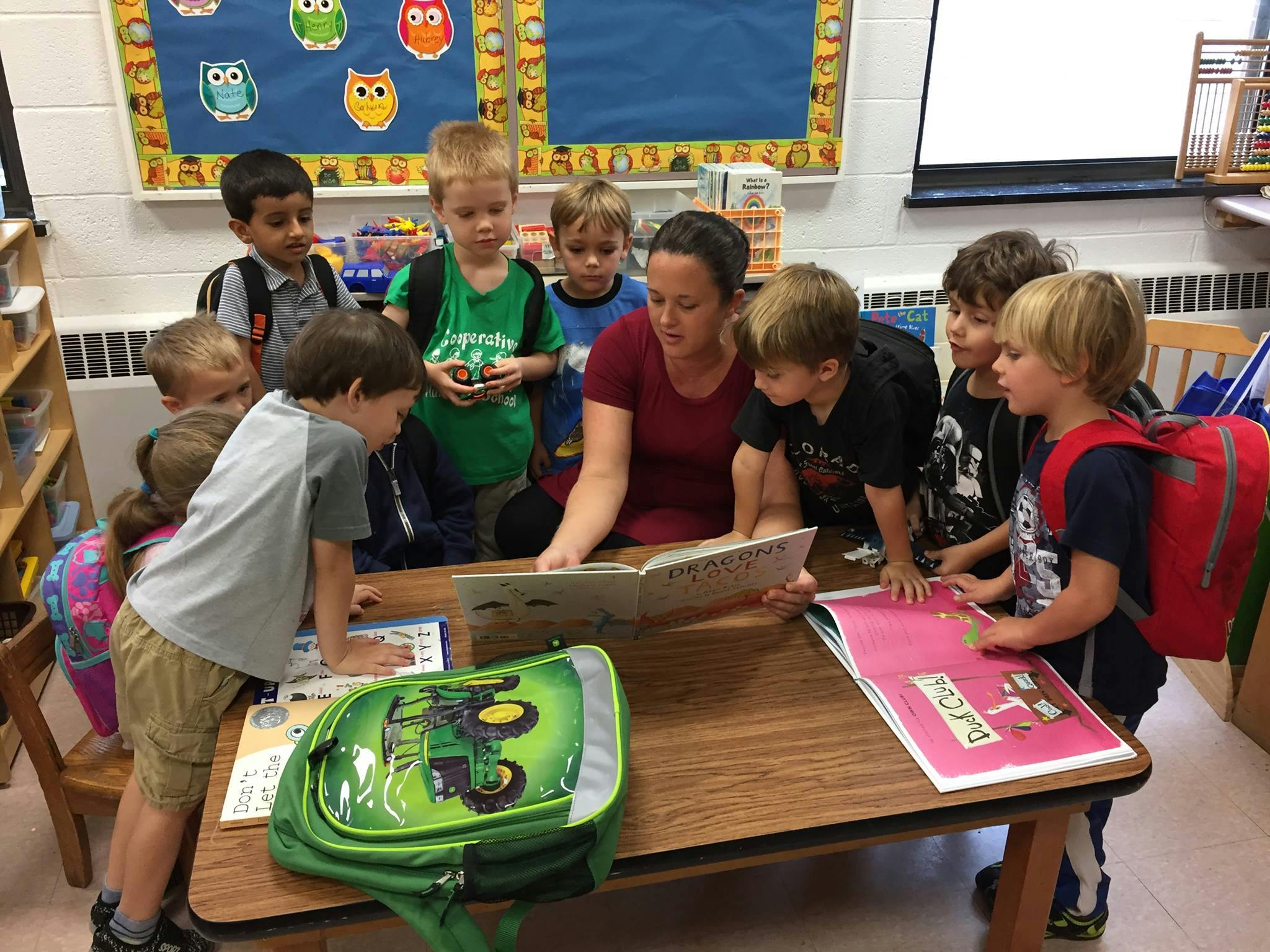 Adult reading a book to children in a classroom