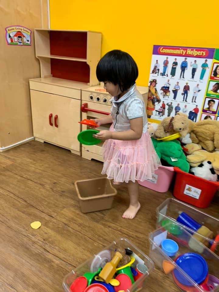 Child playing with toy kitchen set