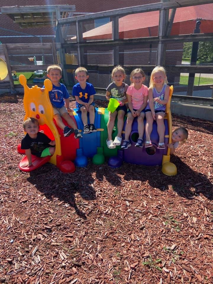 Children sitting on a colorful caterpillar playground structure