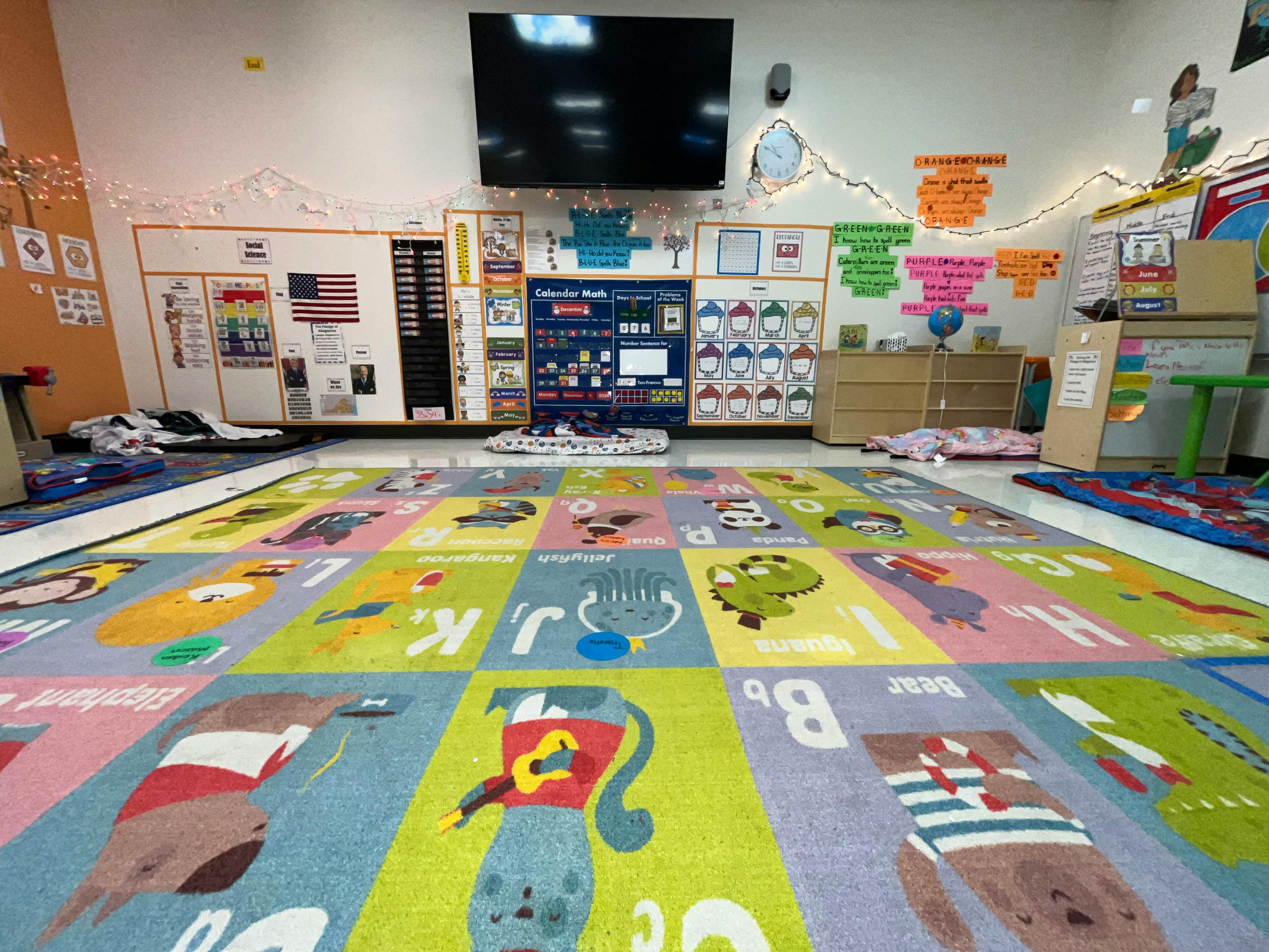Classroom with an alphabet rug and various learning materials on the walls