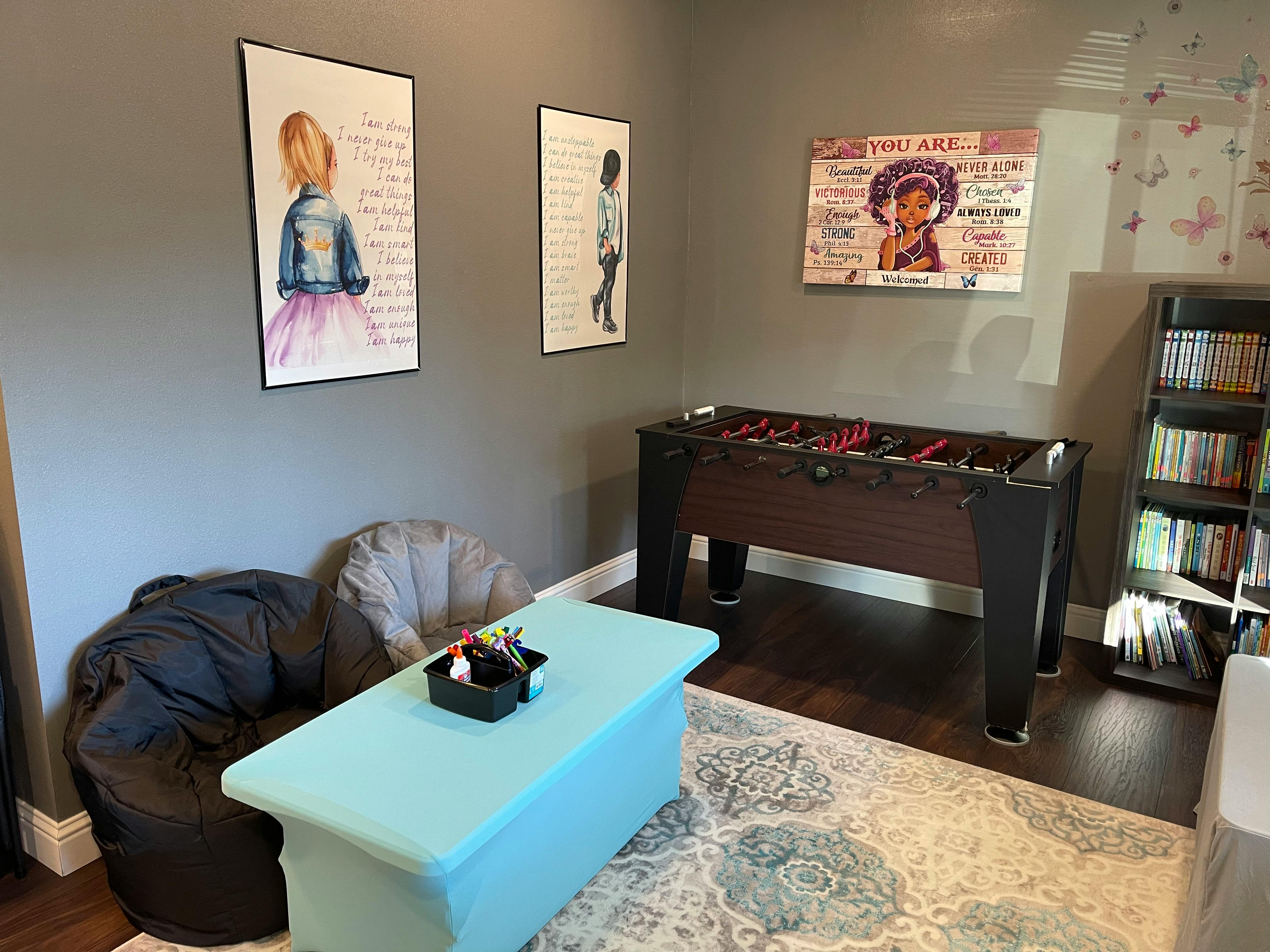 Foosball table in a room with artwork and a bookshelf