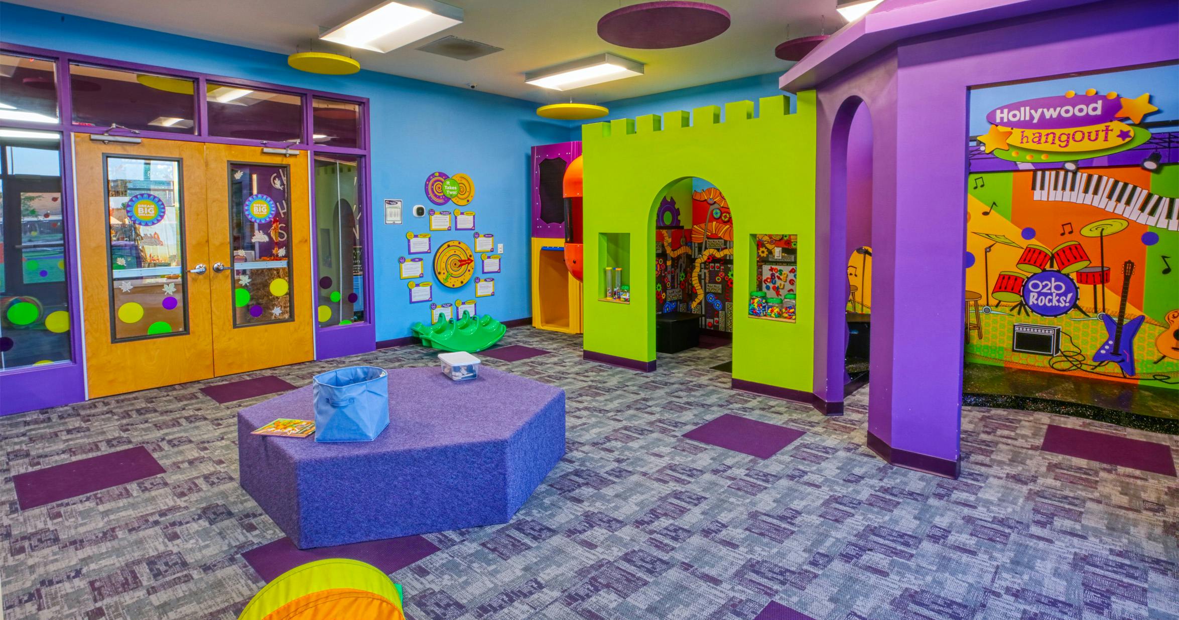 Colorful playroom with a play castle, vibrant walls, and patterned carpet