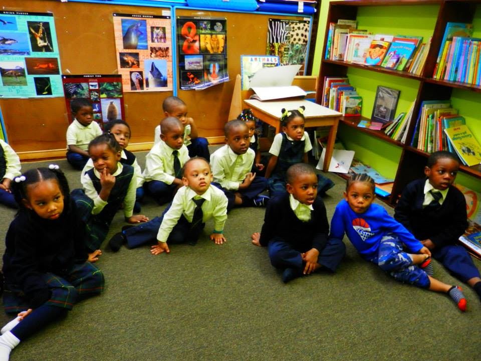 Group of children sitting on a carpeted floor in a classroom