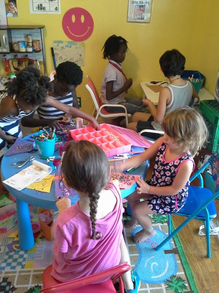 Children sitting at tables and playing in a classroom