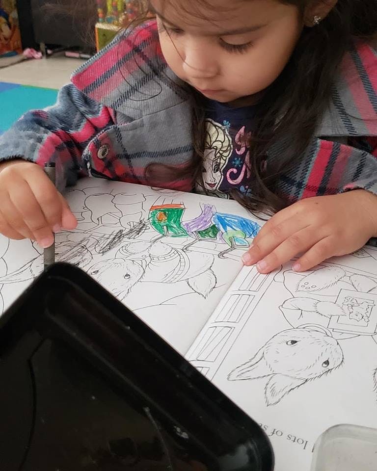 Child coloring in a book with crayons