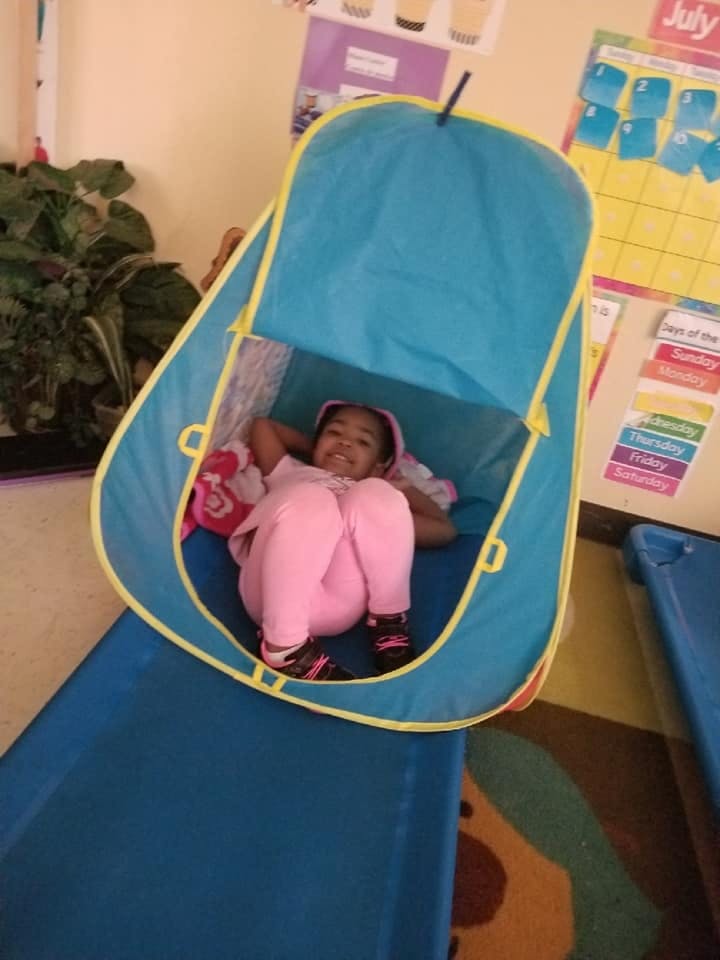 Child in a blue pop-up tent