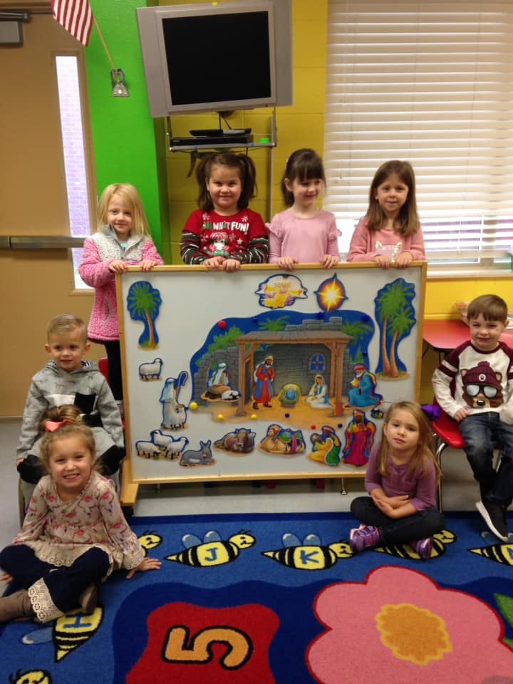 Group of children posing with a nativity scene display