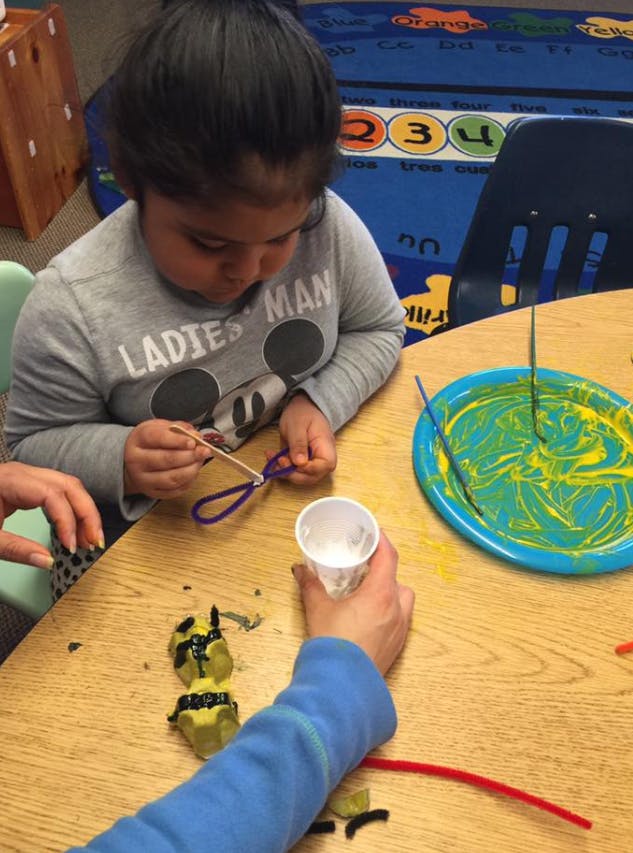 Child doing a craft at a table