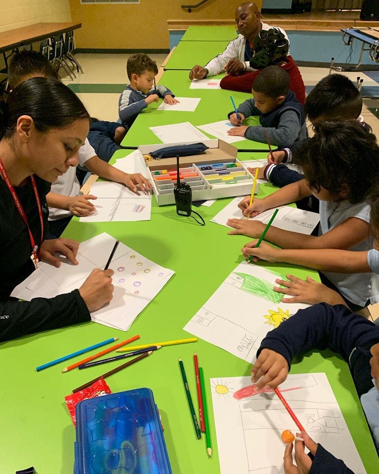 Adults and children drawing at a table