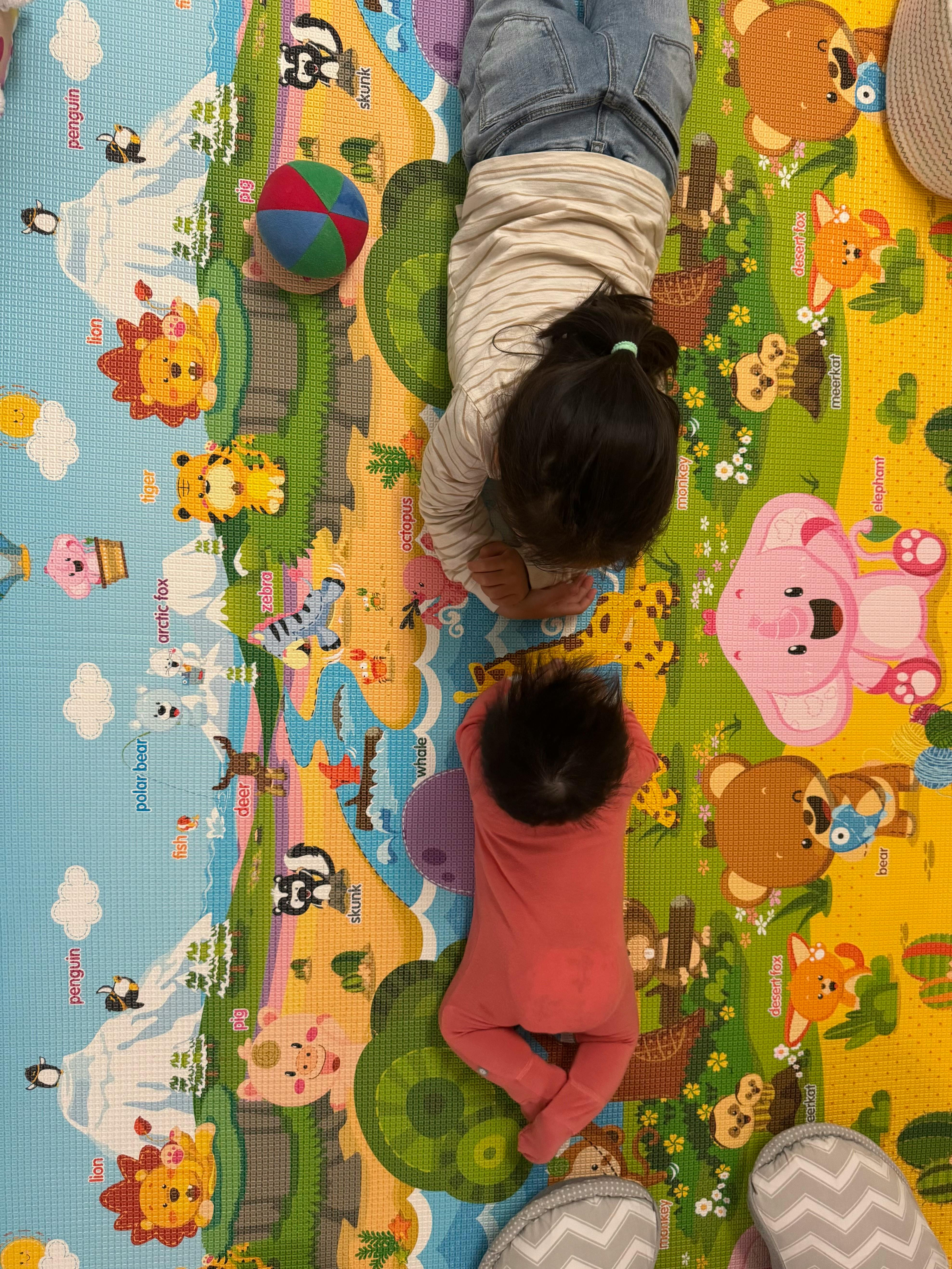 Two children playing on a colorful mat
