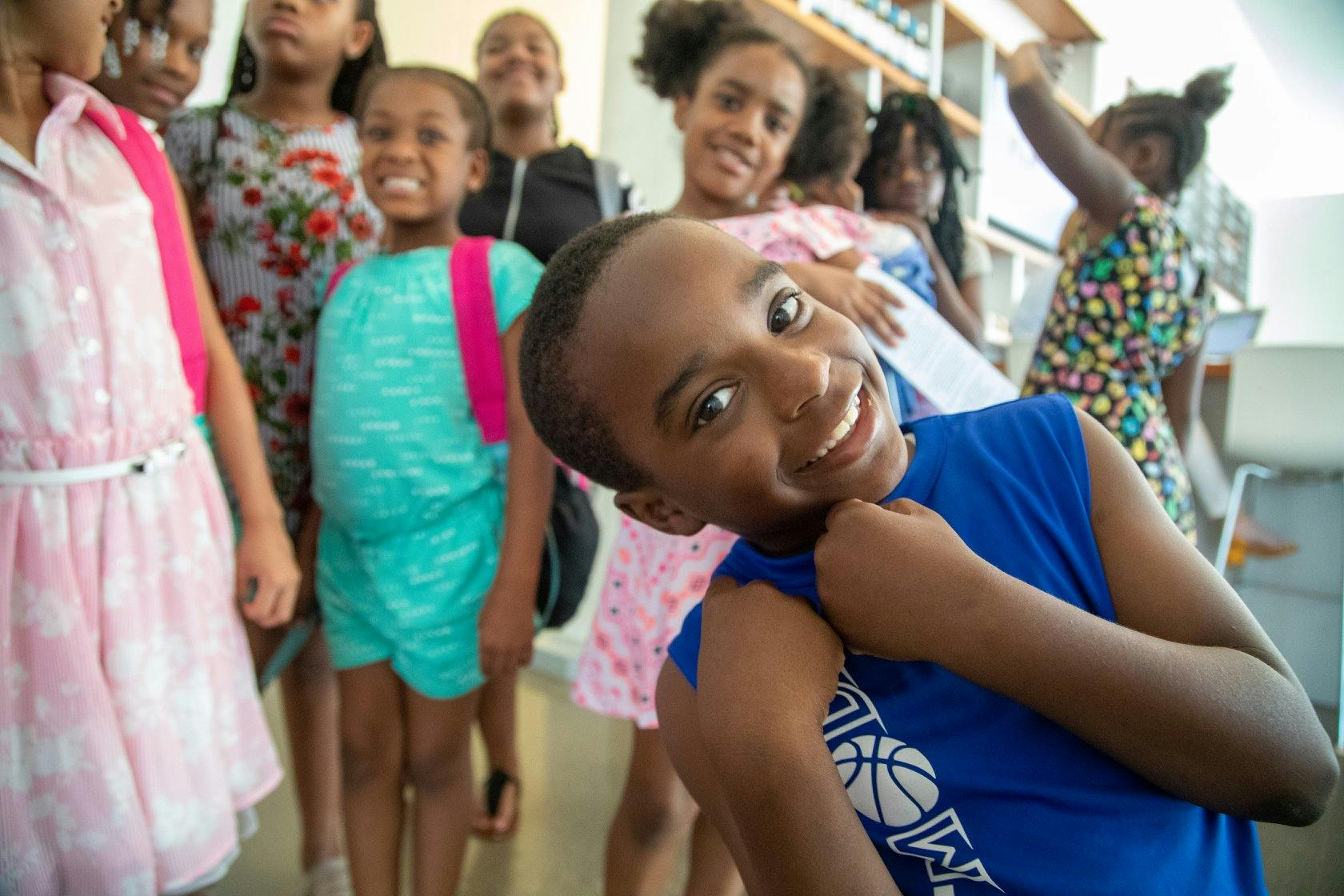 Group of children, one child in foreground smiling at camera