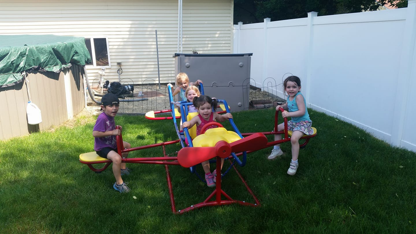 Children playing on a seesaw in a yard