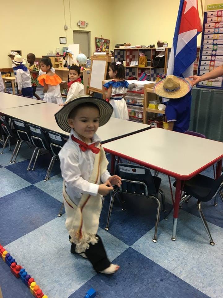 Child in a classroom wearing a hat and costume
