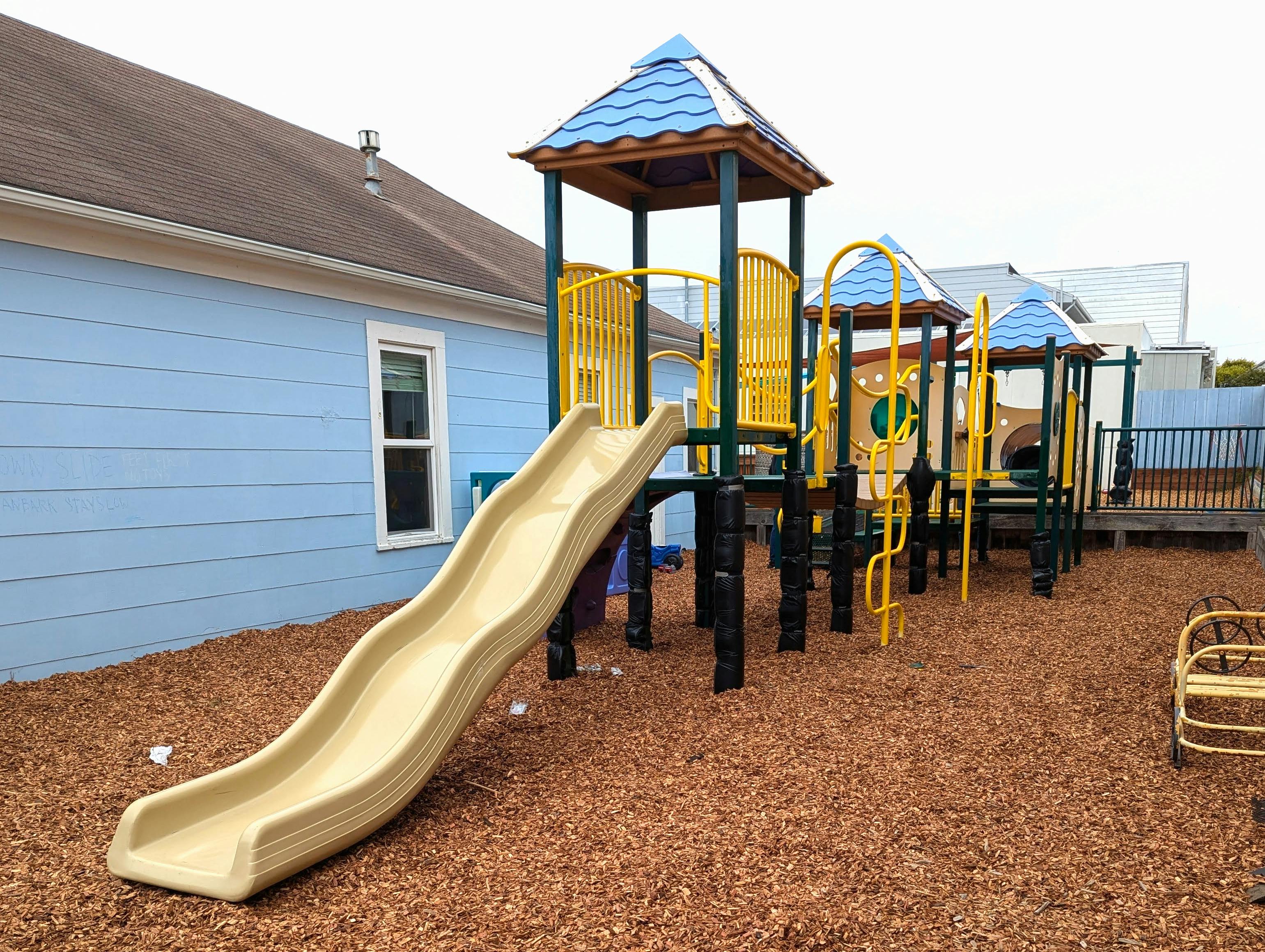 Playground with slide and climbing structures on wood chips