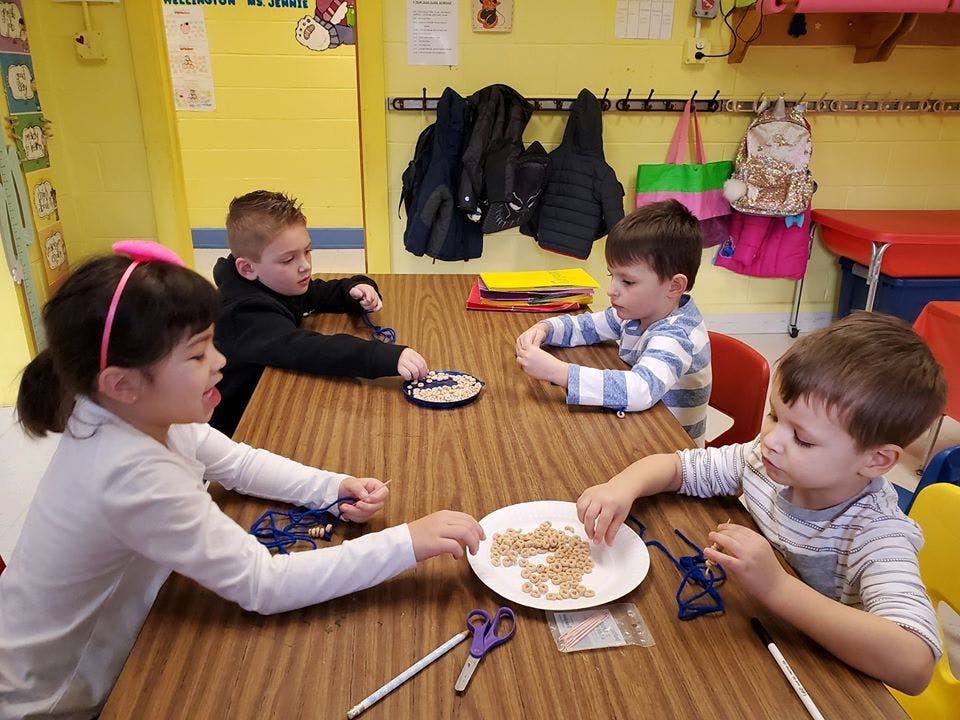 Four children sitting at a table doing crafts