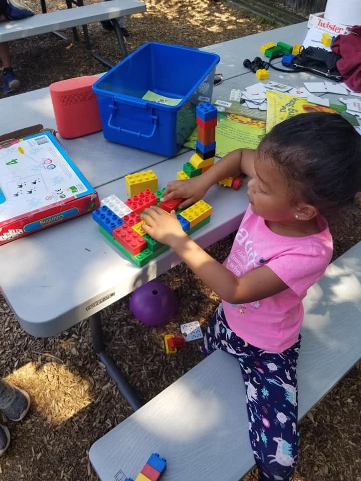 Child playing with colorful building blocks on a table