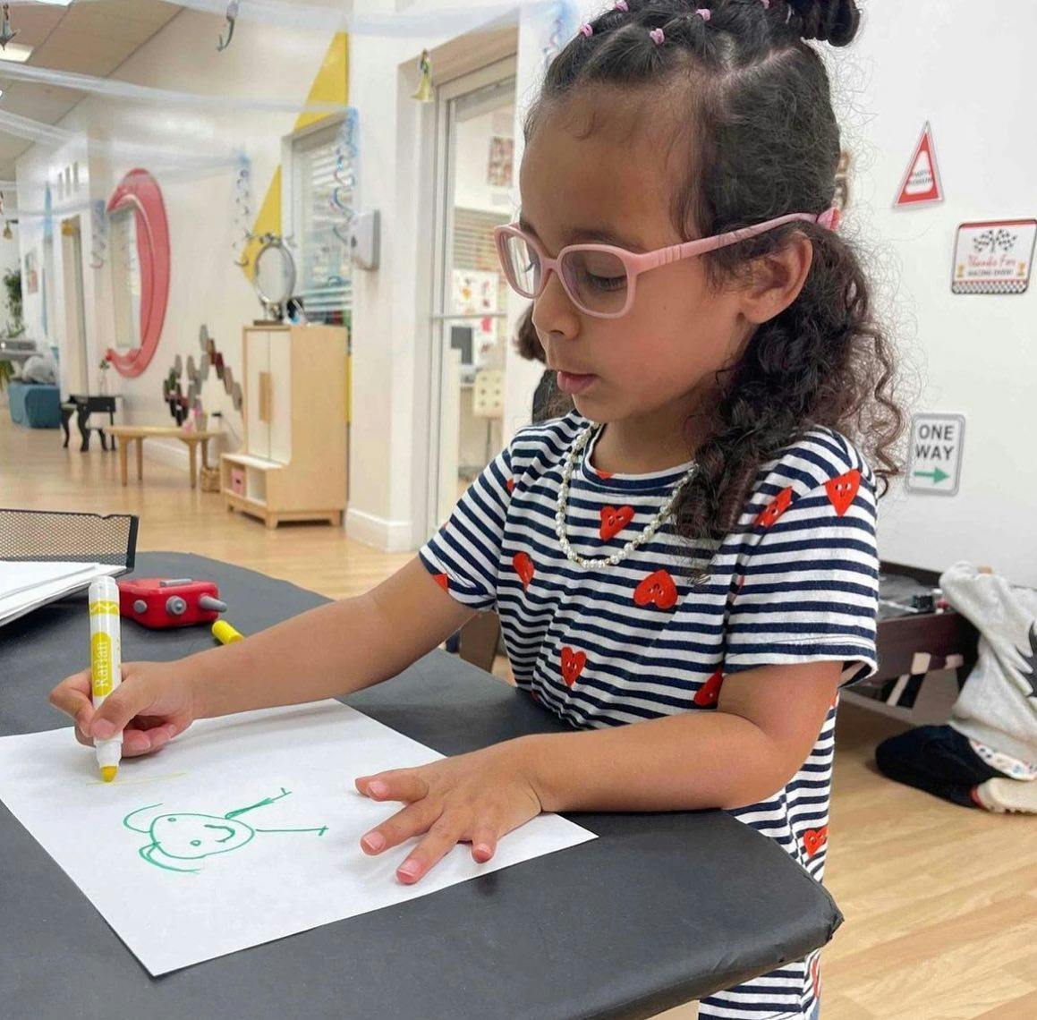 Child drawing on paper with a marker