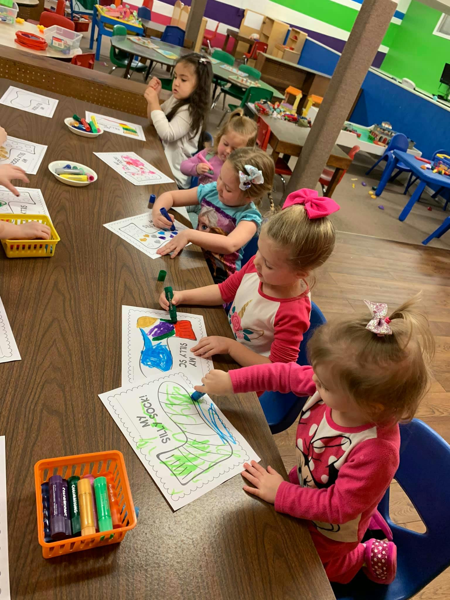 Children coloring at a table in a classroom