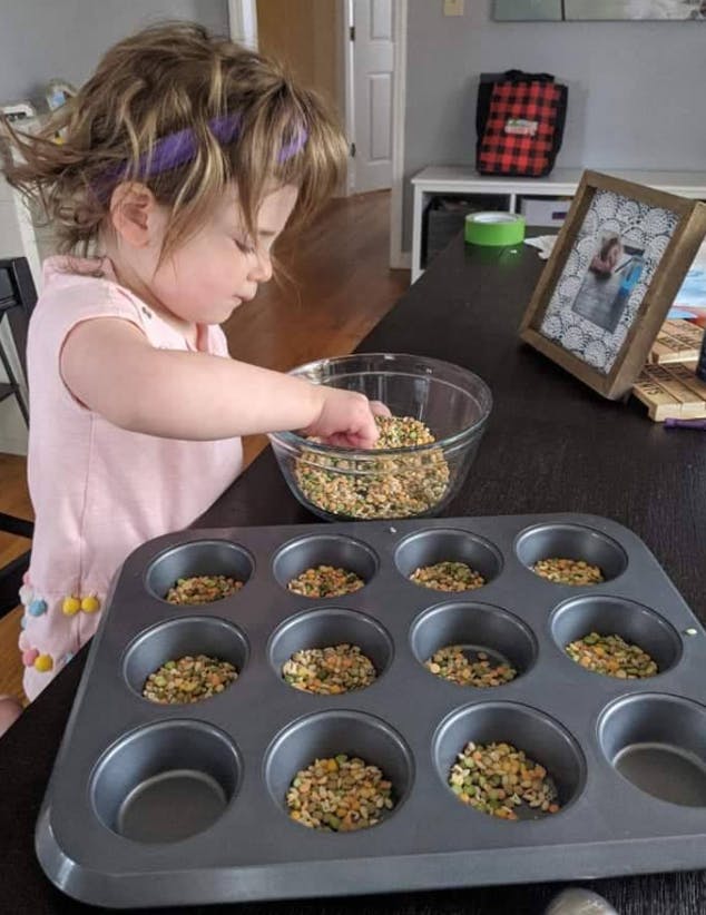 Child putting ingredients into a muffin tin