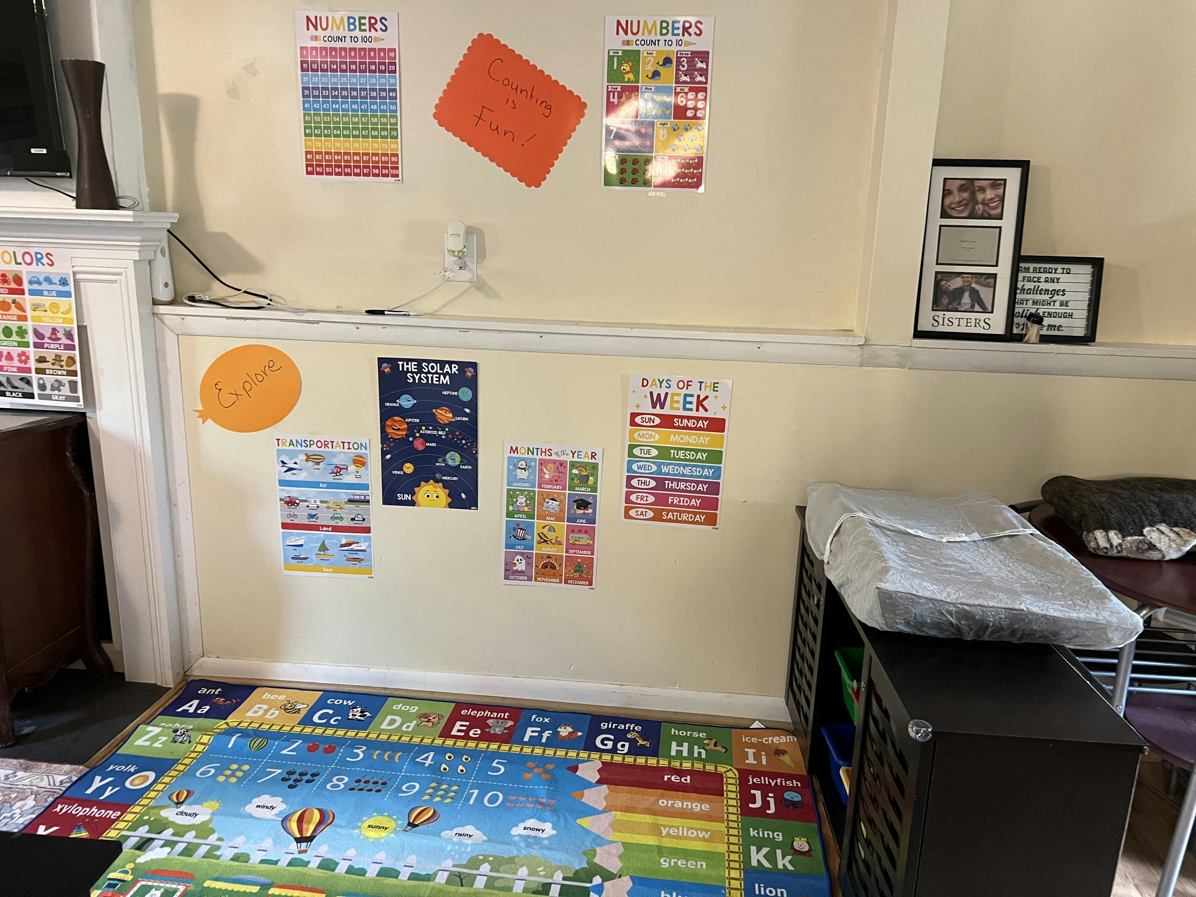 Playroom with educational posters on walls and a colorful alphabet rug on the floor