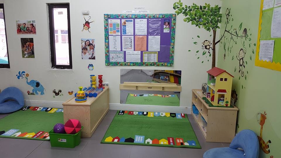 Playroom with green rugs, toys, and wall decorations