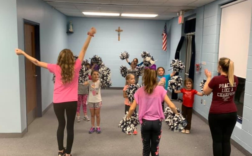 People and children with pom-poms in a room