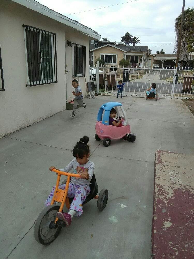 Children playing with ride-on toys outdoors